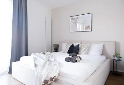 a bedroom with a white bed with a teddy bear on it at Rentero Michelska Residence Scandinavian Quiet Apartment, Prague in Prague