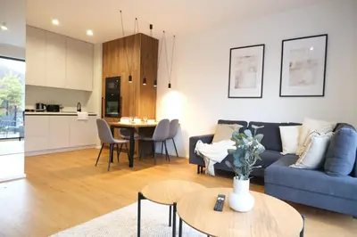 a living room with a blue couch and a table at Rentero Michelska Residence Scandinavian Quiet Apartment, Prague in Prague