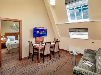 a living room with a table and chairs and a bedroom at Crown Palace Apartments by Adrez in Prague