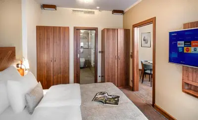 a hotel room with a bed and a television at Crown Palace Apartments by Adrez in Prague