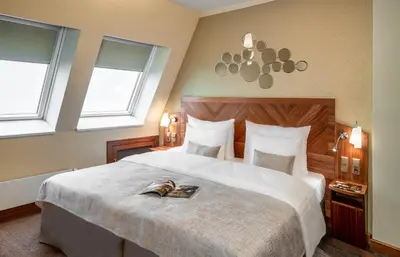 a bedroom with a large bed with a book on it at Crown Palace Apartments by Adrez in Prague