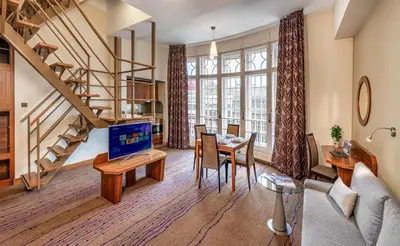 a living room with a table with a laptop on it at Crown Palace Apartments by Adrez in Prague