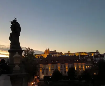 a statue in front of a city at sunset at Valentinka Minutes away from Charles Bridge in Prague