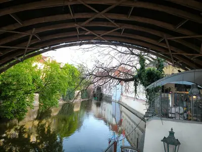 a bridge over a canal with a river underneath it at Valentinka Minutes away from Charles Bridge in Prague