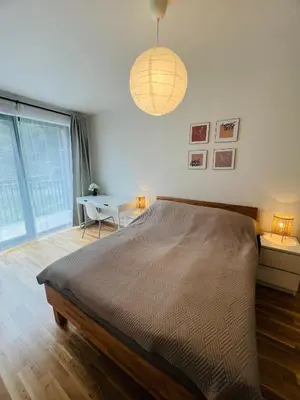 a bedroom with a large bed and a table at Nika Apartments Prague 5 in Prague