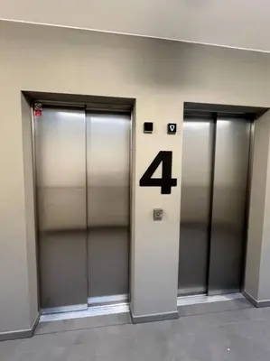 three elevator doors in a building with the number four at Nika Apartments Prague 5 in Prague