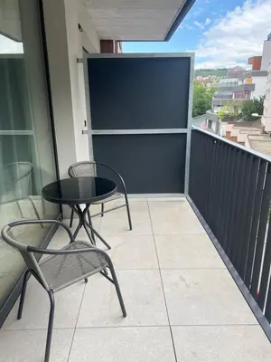 a patio with a table and chairs on a balcony at Nika Apartments Prague 5 in Prague