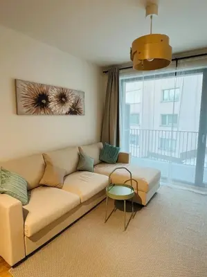 a living room with a couch and a large window at Nika Apartments Prague 5 in Prague