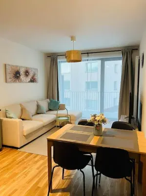 a living room with a couch and a table with chairs at Nika Apartments Prague 5 in Prague
