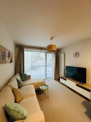 a living room with a couch and a television at Nika Apartments Prague 5 in Prague