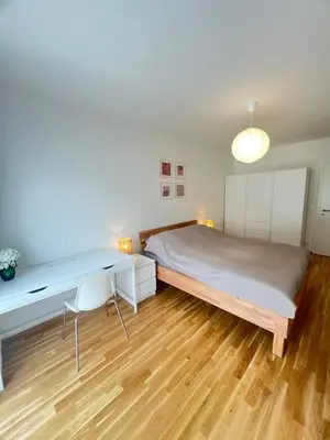 a bedroom with a large bed and a desk at Nika Apartments Prague 5 in Prague