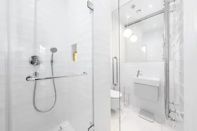 a white bathroom with a shower and a sink at Luxury apartment in the center in Prague