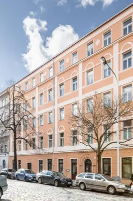 a large pink building with cars parked in front of it at TurnKey I Karlín Square Apartments in Prague