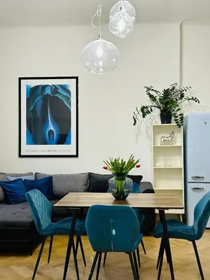 a living room with a table and blue chairs at River Site Apartment Janáčkovo nábřeží 27 in Prague