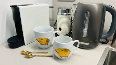 a counter with two mugs and a coffee maker at River Site Apartment Janáčkovo nábřeží 27 in Prague