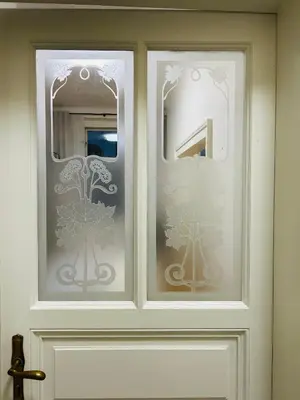 a white door with two glass panels with trees on it at River Site Apartment Janáčkovo nábřeží 27 in Prague