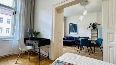 a bedroom with a living room with a table and chairs at River Site Apartment Janáčkovo nábřeží 27 in Prague