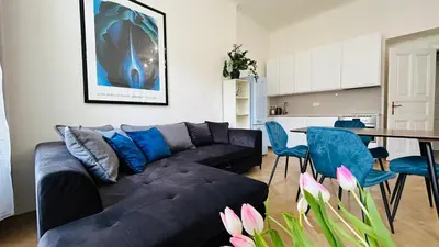 a living room with a black couch and a table at River Site Apartment Janáčkovo nábřeží 27 in Prague