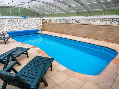 a swimming pool with two chairs and a table at Holiday Home Malovidy by Interhome in Rataje nad Sázavou