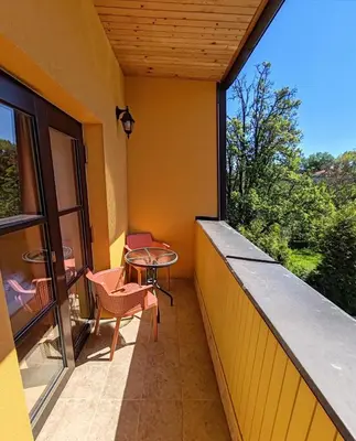 a balcony with a table and chairs and a window at Pension Trojská in Prague
