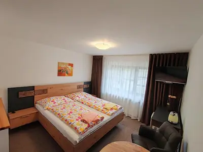 a bedroom with a bed and a chair at Pension Trojská in Prague