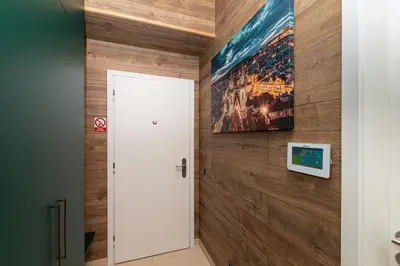 a hallway with a white door and a painting on a wall at LUX PRAHA in Prague