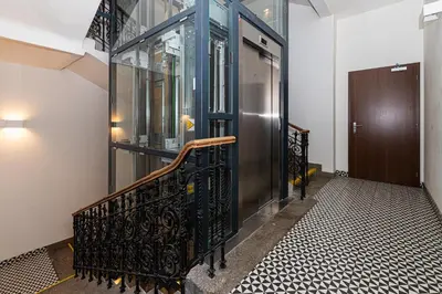 a hallway with a staircase with a glass door and a wooden door at LUX PRAHA in Prague