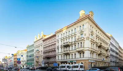 a large white building with cars parked in front of it at LUX PRAHA in Prague