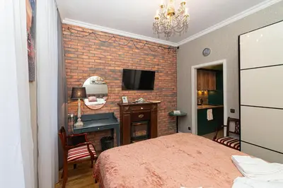 a bedroom with a bed and a brick wall at LUX PRAHA in Prague