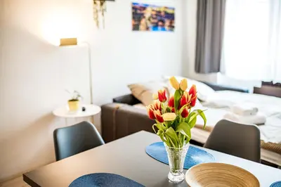 a dining room table with a vase of flowers on it at Fritscher Apartments, s.r.o. in Prague