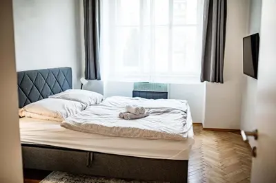 a bed with a teddy bear laying on it at Fritscher Apartments, s.r.o. in Prague