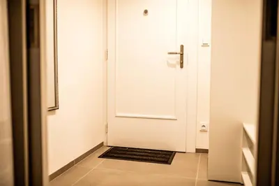 a white door with a black mat in a hallway at Fritscher Apartments, s.r.o. in Prague