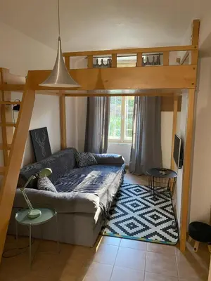 a living room with a couch under a bunk bed at Cozy Garden Apartment in the heart of Prague in Prague