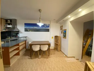 a kitchen with a wooden table and two white chairs at Cozy Garden Apartment in the heart of Prague in Prague