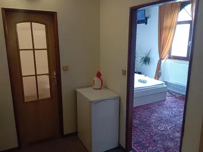 a room with a refrigerator and a door with a window at Penzion Flídr in Poděbrady