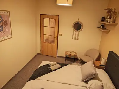 a bedroom with a bed and a table and a chair at Penzion Flídr in Poděbrady