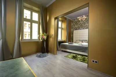 a bedroom with a blue bed and a window at Vltava Design Apartments in Prague