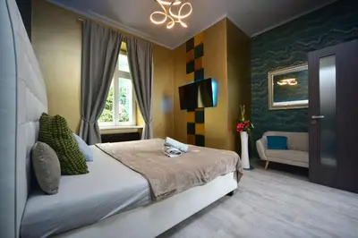 a white bedroom with a bed and a table at Vltava Design Apartments in Prague