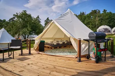 a tent with a grill on a wooden deck at Glamping Slapy in Slapy