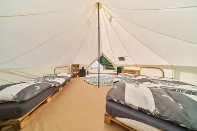 a tent with three beds in a room at Glamping Slapy in Slapy
