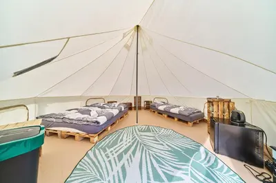 a room with two beds and a tv in a tent at Glamping Slapy in Slapy