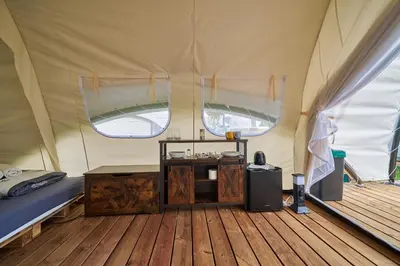 a tent with a bed and a table in it at Glamping Slapy in Slapy