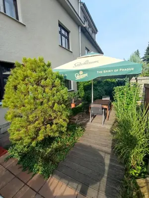 a patio with a table and an umbrella in front of a building at Pension 21 in Prague
