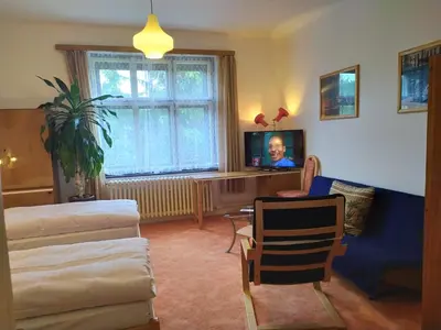 a living room with a tv and a woman on the screen at Pension 21 in Prague