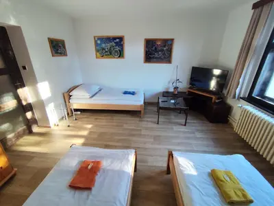 a living room with two beds and a television at Pension 21 in Prague