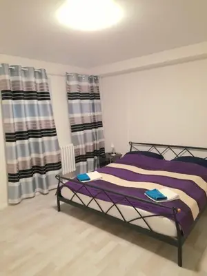 a bedroom with a bed with purple sheets and curtains at LEV I SOVA in Mělník
