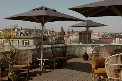 a deck with chairs and tables and umbrellas at The Cloud One Prague in Prague
