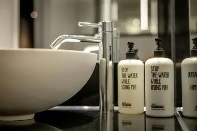 a counter with four bottles of soap and a sink at The Cloud One Prague in Prague