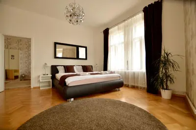 a bedroom with a bed and a chandelier at Beautiful Apartments in Prague in Prague