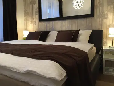 a bedroom with a large bed with brown and white sheets at Beautiful Apartments in Prague in Prague